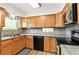 Functional kitchen with light wood cabinets, granite countertops, and modern appliances at 7350 Devinney Ct, Arvada, CO 80005