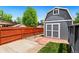 Storage shed with double doors, concrete pad, and privacy fence at 7350 Devinney Ct, Arvada, CO 80005
