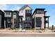 Modern three-story home featuring gray and black siding, stone accents, and well-manicured landscaping at 1793 W 166Th Ave, Broomfield, CO 80023