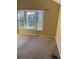 Bright, carpeted bedroom featuring large windows offering ample natural light and exterior views at 16901 E Chenango Ave # E, Aurora, CO 80015