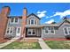 Charming gray townhome with red brick chimney, green lawn, and blue sky at 16901 E Chenango Ave # E, Aurora, CO 80015