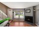 Cozy living room featuring a fireplace, wood floors, and large double windows at 16901 E Chenango Ave # E, Aurora, CO 80015