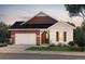 Charming single-story home featuring a brick accent wall, a two-car garage, and a covered front porch at 8664 S Quemoy St, Aurora, CO 80016