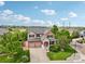 Stunning aerial view of a brick and tan two-story home with a well-manicured lawn and a two car garage at 641 Briar Haven Dr, Castle Pines, CO 80108