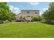 Expansive backyard featuring a large, well-maintained lawn, wooden fence, a deck and stone patio area at 641 Briar Haven Dr, Castle Pines, CO 80108