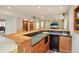 Basement bar area with bar seating, oak cabinetry, and a convenient mini-fridge at 641 Briar Haven Dr, Castle Pines, CO 80108