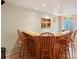 Basement bar area with wooden bar and stools and a neon beer sign at 641 Briar Haven Dr, Castle Pines, CO 80108