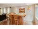 Basement bar area with wooden bar and stools and display shelving at 641 Briar Haven Dr, Castle Pines, CO 80108