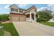 Charming two-story home featuring a brick facade, covered porch, and attached two-car garage at 641 Briar Haven Dr, Castle Pines, CO 80108