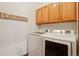 Well-equipped laundry room with a modern washer and dryer, complemented by overhead cabinetry at 641 Briar Haven Dr, Castle Pines, CO 80108