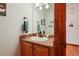 Powder room featuring a single sink, oak cabinet, and a decorative towel hanger at 641 Briar Haven Dr, Castle Pines, CO 80108