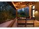Covered backyard patio with comfortable seating, string lights, and a ceiling fan overlooking lush greenery at 2060 Hoyt St, Lakewood, CO 80215