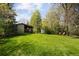 Sprawling backyard featuring a lush green lawn, mature trees, and a charming home with an inviting outdoor space at 2060 Hoyt St, Lakewood, CO 80215