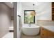 Bathroom featuring soaking tub, walk-in shower, and bright window at 2060 Hoyt St, Lakewood, CO 80215