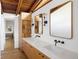 Bathroom featuring double sinks, wood accents, and decorative lighting at 2060 Hoyt St, Lakewood, CO 80215