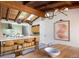 Modern kitchen featuring a large island with seating, wood beams, and stylish light fixtures at 2060 Hoyt St, Lakewood, CO 80215