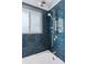 Modern bathroom featuring stylish blue subway tile, a shower head with great water pressure, and a window at 11338 Donley Dr, Parker, CO 80138