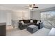 Bright living room with plush gray sectional sofa, ottoman, ceiling fan, and a large window at 11338 Donley Dr, Parker, CO 80138