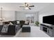 Inviting living room with gray sectional sofa, ceiling fan, a window and modern entertainment center at 11338 Donley Dr, Parker, CO 80138