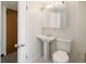 A compact bathroom featuring a pedestal sink, standard toilet, and a mirrored medicine cabinet at 7475 W Vassar Ave, Lakewood, CO 80227