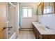 Bright bathroom features a shower, tub, double sink vanity, and ceramic tile floor at 7475 W Vassar Ave, Lakewood, CO 80227