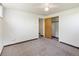 Standard bedroom featuring neutral carpet, white walls, ceiling fan, and closet with a wooden door at 7475 W Vassar Ave, Lakewood, CO 80227