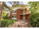 Charming red brick home featuring a unique balcony and mature landscaping at 7475 W Vassar Ave, Lakewood, CO 80227