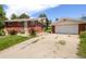 Red brick house with a detached garage and gravel driveway at 7475 W Vassar Ave, Lakewood, CO 80227