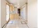 Bright kitchen featuring tile floors, wood cabinets, and a door leading to the exterior at 7475 W Vassar Ave, Lakewood, CO 80227
