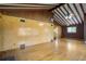 Expansive living room with beamed ceiling, wood floors and brick accent wall at 7475 W Vassar Ave, Lakewood, CO 80227