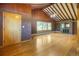 Spacious living room boasts a fireplace, wood floors, beamed ceiling, and bright windows at 7475 W Vassar Ave, Lakewood, CO 80227