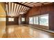 Bright, expansive living room with wood floors, brick accent walls, beamed ceiling, and large windows at 7475 W Vassar Ave, Lakewood, CO 80227