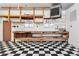 Spacious garage with workbench, shelving, and black and white checkered floor at 8881 Lilly Dr, Thornton, CO 80229