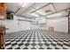 Spacious garage featuring checkered tile floor and ample storage shelving at 8881 Lilly Dr, Thornton, CO 80229