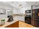 Modern kitchen with skylight featuring white cabinets, butcher block countertops, and stainless steel appliances at 8881 Lilly Dr, Thornton, CO 80229
