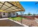 Charming backyard patio featuring a decorative metal awning with a lush green lawn at 8881 Lilly Dr, Thornton, CO 80229