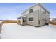 Two-story house exterior with covered patio and snowy yard at 4527 Boone Cir, Brighton, CO 80601