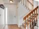 Inviting entryway featuring tile flooring, a coat rack, and a staircase with wooden banister at 8394 S Everett Way # E, Littleton, CO 80128