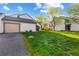 Exterior view showcasing a townhome with well-maintained lawn, garage and driveway at 8394 S Everett Way # E, Littleton, CO 80128