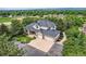Aerial view of large home with a three-car garage, mature trees, and lush landscaping at 6335 Oberon Rd, Arvada, CO 80004