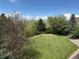 Private back yard featuring lush greenery, mature trees, and a manicured lawn at 6335 Oberon Rd, Arvada, CO 80004