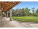 Backyard walkout patio with large manicured lawn and mature trees beyond at 6335 Oberon Rd, Arvada, CO 80004
