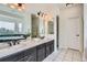Primary bath features dual sinks, large vanity, updated lighting, bathtub and walk-in shower at 6335 Oberon Rd, Arvada, CO 80004