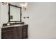 Powder bath features dark vanity, granite counters, decorative mirror and lighting at 6335 Oberon Rd, Arvada, CO 80004