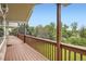 Large wooden deck with decorative railings and beautiful views of backyard and surrounding trees at 6335 Oberon Rd, Arvada, CO 80004