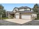 Attractive two-story home features a brick facade, an attached three-car garage, and well maintained landscaping at 6335 Oberon Rd, Arvada, CO 80004
