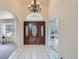 Grand foyer featuring tile flooring, a decorative front door with sidelights, and an elegant chandelier at 6335 Oberon Rd, Arvada, CO 80004