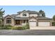 Charming two-story home with a brick facade, gray roof, manicured landscaping, and a three-car garage at 6335 Oberon Rd, Arvada, CO 80004