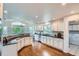 Open kitchen with stainless steel appliances, granite counters, hardwood floors and breakfast nook with wooded views at 6335 Oberon Rd, Arvada, CO 80004