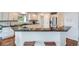 Bright kitchen features granite counters, wooden floors, white cabinets, and stainless steel appliances at 6335 Oberon Rd, Arvada, CO 80004